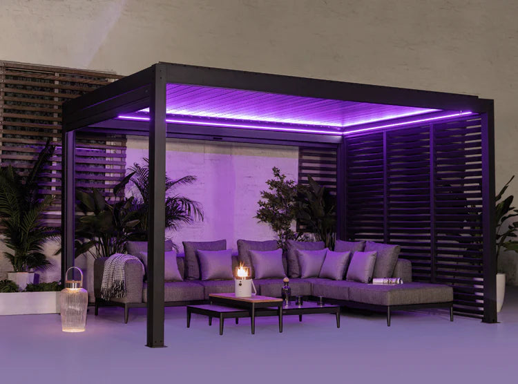 Eine Pergola aus Aluminium, von Simpo Lifestyle. Beleuchtet mit Lila Led-Lichtern und einem wundervollem Sofa mit Tisch.